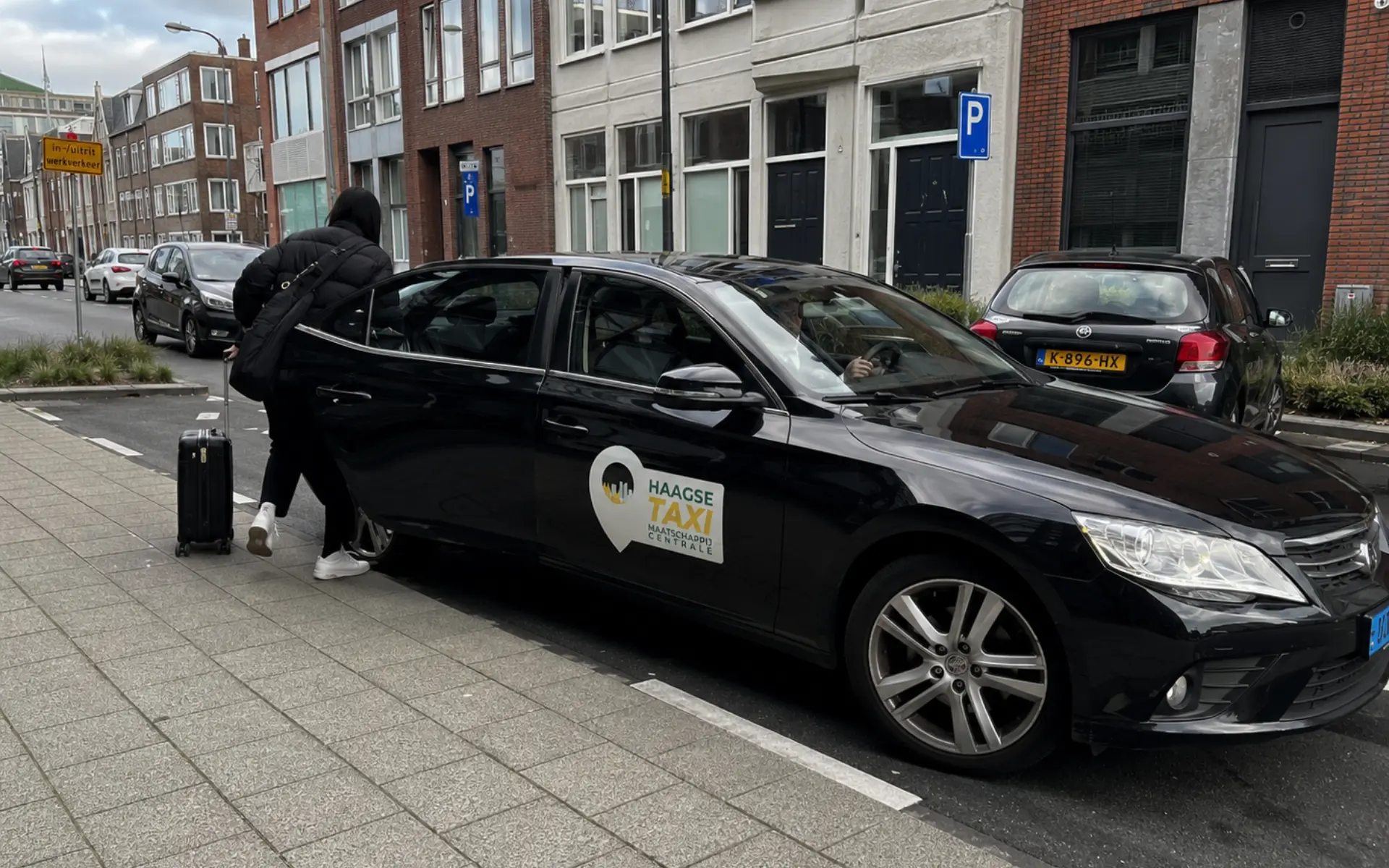 Persoon stap in taxi van Haagse Taxi Maatschappij Centrale